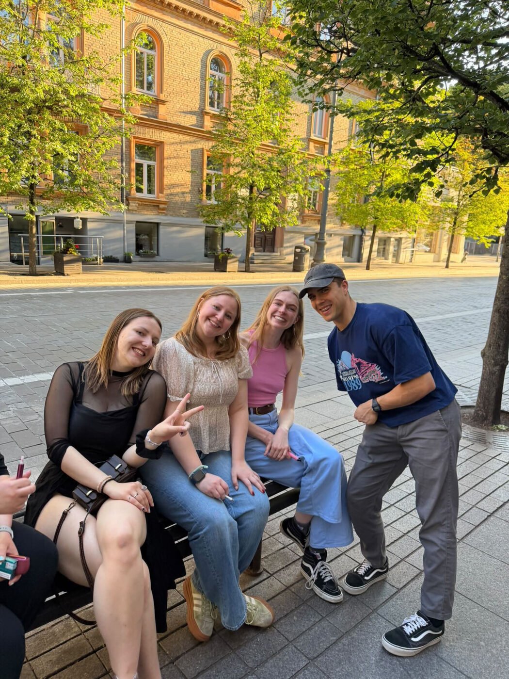 Urtė with friends on a bench in the evening sun